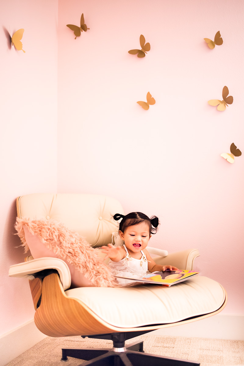 toddler girl pink nursery, eames lounge chair reading nook, floating butterflies wall decor
